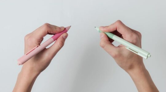 Ambidextr.,Female,Hands,Hold,Pens,And,Write,On,White,Background.