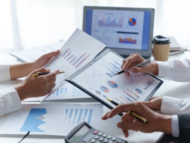 Business,People,Point,To,Graph,And,Chart,To,Analyze,Market