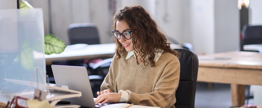 Young,Happy,Professional,Business,Woman,Employee,Sitting,At,Desk,Working