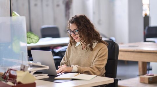 Young,Happy,Professional,Business,Woman,Employee,Sitting,At,Desk,Working