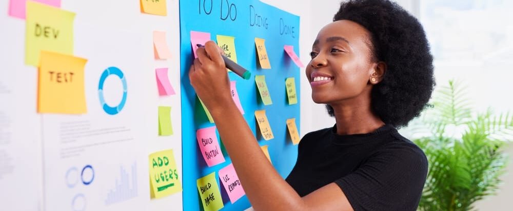 Black,Woman,Scrummaster,Writes,On,Kanban,Board,With,Ticket,Backlog,