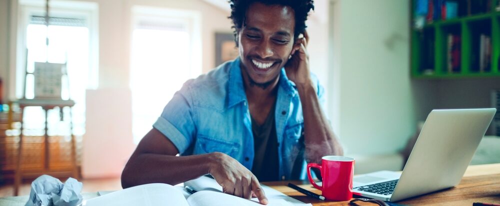 Young,Man,Of,African,Ethnicity,Studying,And,Using,The,Laptop