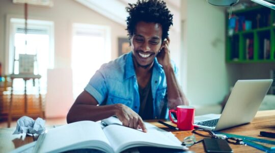 Young,Man,Of,African,Ethnicity,Studying,And,Using,The,Laptop