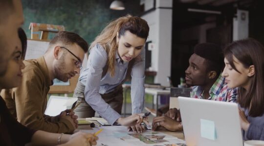 Brunette,Female,Team,Leader,Talking,With,Mixed,Race,Group,Of
