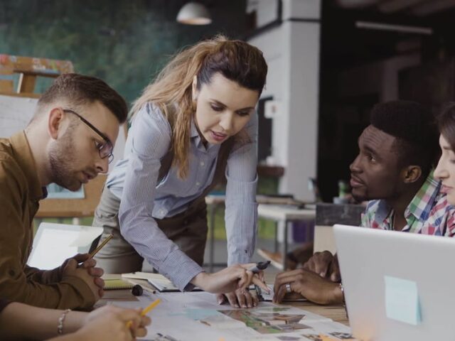 Brunette,Female,Team,Leader,Talking,With,Mixed,Race,Group,Of